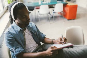 man listening to music and writing
